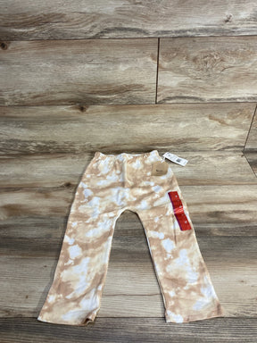 Beige and white tie-dye toddler pants with elastic waist, laid flat on wood background