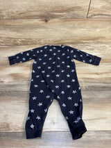 Back view of baby sleeper in black showcasing white star print with long sleeves and ribbed cuffs on wood plank floor