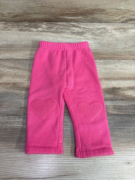Old Navy baby pink pull-on pants with heart-shaped knee patches on a wooden background