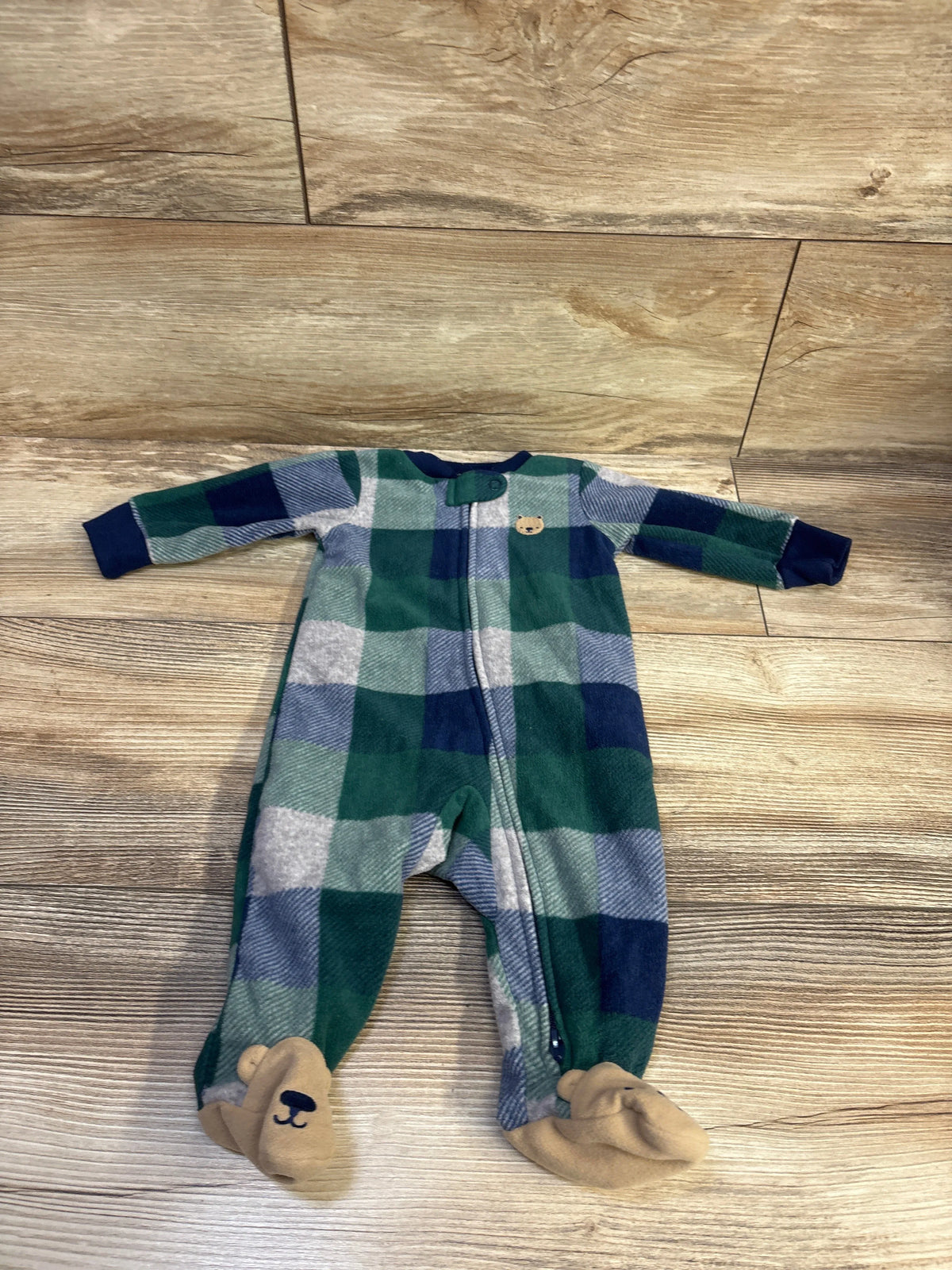 Top view of Carters blanket sleeper for 3 months showcasing green plaid, front zipper, and bear face footies on a wood floor