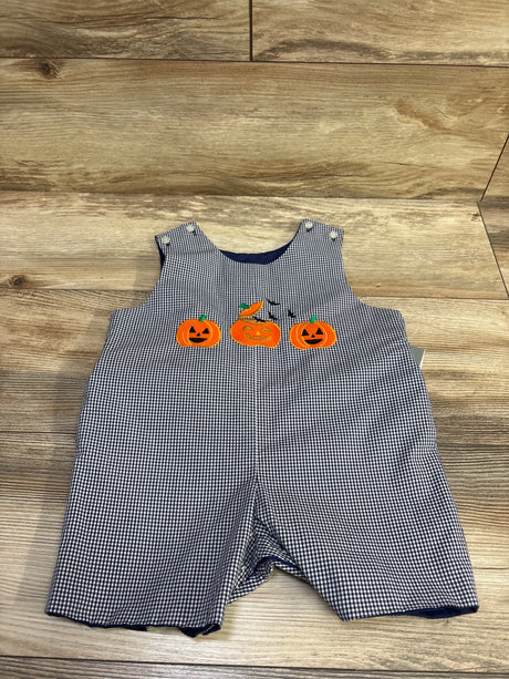 Front view of navy gingham romper showcasing three embroidered pumpkins with a wood plank background