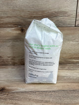 Rear view of Parasol Clear + Dry Bye Bye Rash diaper pack (Size 2, 12 ct) showing green headline text on back on wooden surface