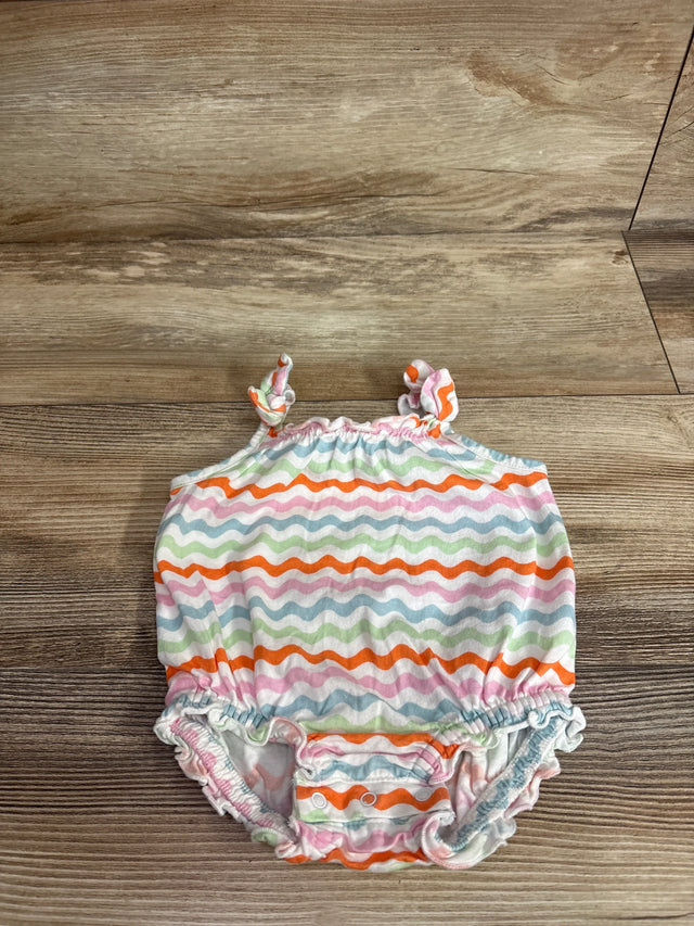 Top view of Old Navy bubble romper in white with wavy rainbow stripes, tie shoulder straps and snap crotch on wood background