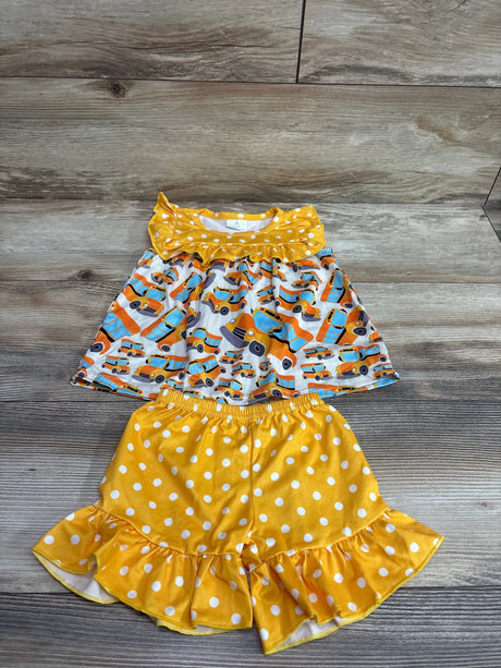 Front view of a two-piece school bus top and shorts set showcasing yellow polka dots and ruffled hems on a wood background