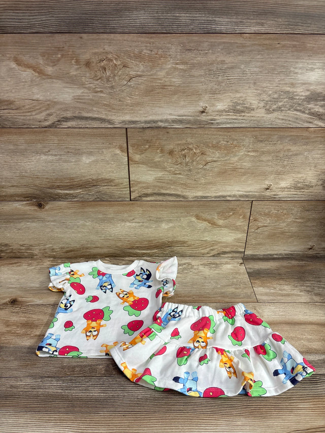 Front view of toddler Bluey strawberry-print top and matching skort showing puff sleeves and elastic waist on wood background