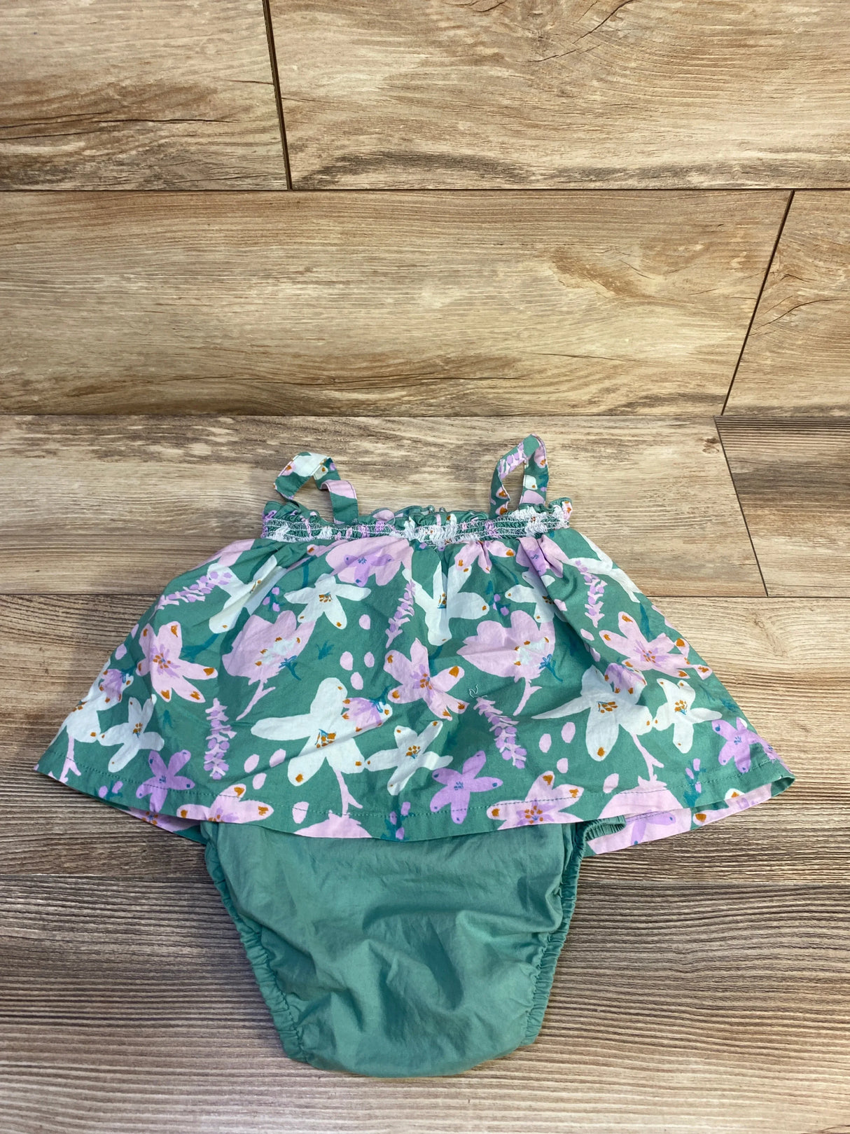Front view of Just One You floral bodysuit dress in green with dragonfly print and tie straps on wood plank floor sz 18m