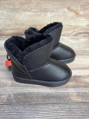 Black faux leather baby boots with soft faux fur lining on wooden background