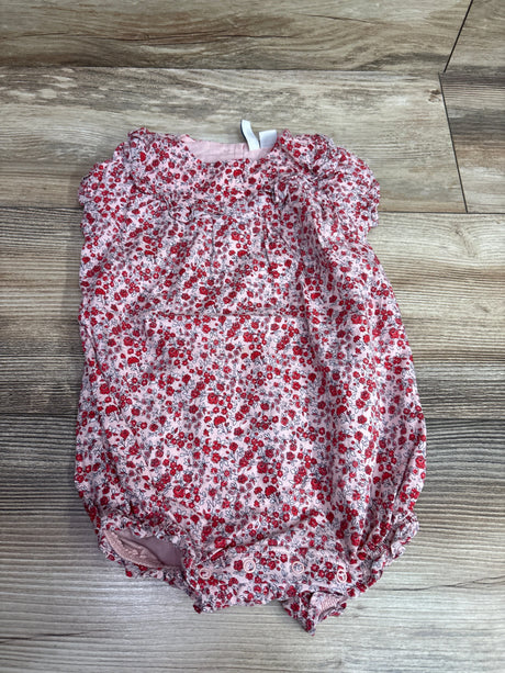 Front view of Janie & Jack pink ditsy floral ruffle romper with snap closures on a wood-grain floor
