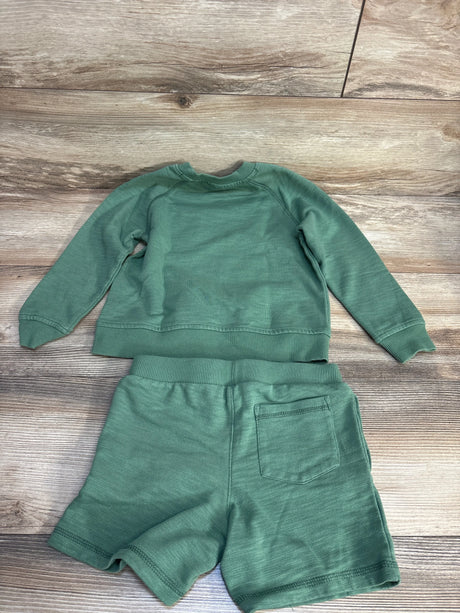 Flat lay of Janie and Jack French Terry 2pc Sweatshirt and Shorts Set in green with crewneck and back patch pocket on wood plank floor