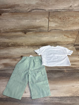 Kids mint green cargo pants and white short sleeve t-shirt on wood floor
