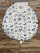 Top-down view of Tiny Adventures reversible 36-inch round baby playmat showing blue construction-vehicle print and packaging label on wood floor