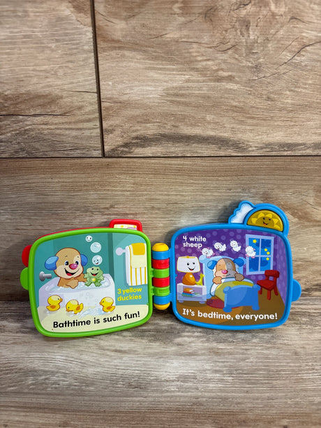 Open Fisher-Price Counting with Puppy electronic book showing bath and bedtime counting pages, colorful hinge on wood floor