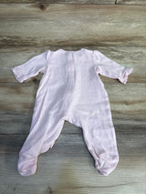Pink baby footed onesie with ruffled sleeves, soft newborn sleepwear on wood floor