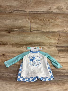 Flat lay of Mickey Mouse rash guard set with white top, blue Mickey print and mint sleeves, blue-and-white shorts, size 9M