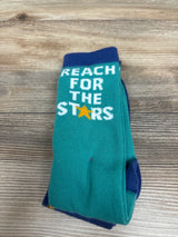 Front view of Cat & Jack knee-high socks showcasing teal fabric, navy trim, and Reach for the Stars text on a wood background