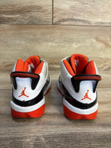 Kids' white and orange Air Jordan 13 sneakers with Jumpman logo, shown from rear on wood floor
