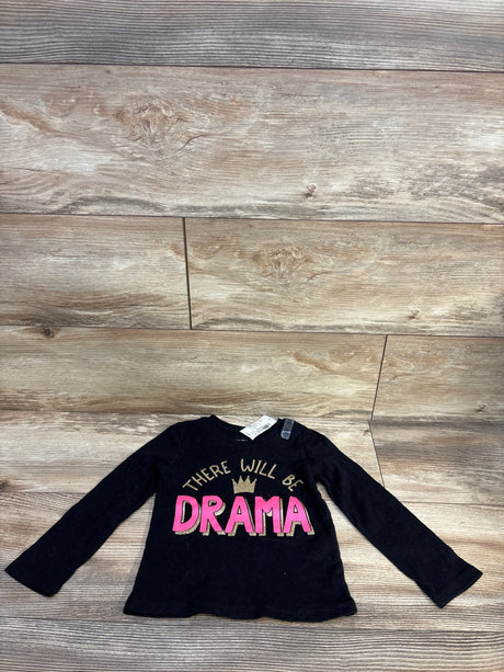 Black long sleeve toddler shirt with 'There Will Be Drama' text and crown graphic on wooden floor