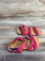 Angled top view of Ositos pink toddler slingback sandals with floral laser-cut straps and buckle on wood background, size 5C