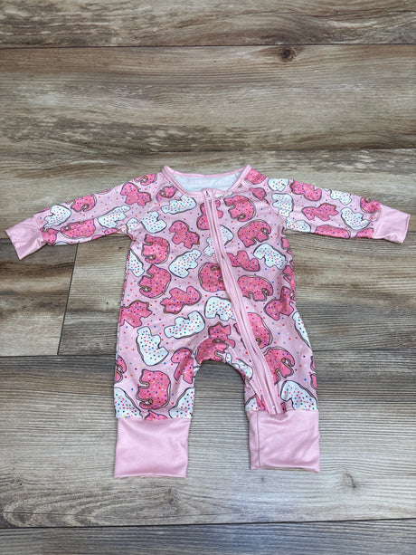 Top view of pink Shein Animal Cracker sleeper with front zipper and animal cracker print on a wood-look background