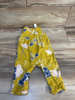 Yellow floral baby romper with blue and pink flowers on wooden floor