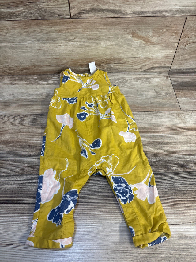Yellow floral baby romper with blue and pink flowers on wooden floor