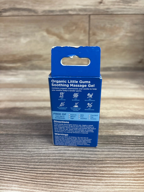 Back view of Mommy’s Bliss Organic Little Gums Soothing Massage Gel package showing directions and allergen information on wood background