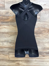 Front view of Blanqi maternity crossback tank with crossed straps, front keyhole and fitted black body on wood background