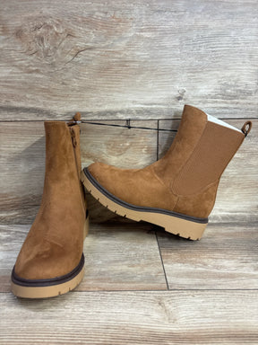 Tan suede kids ankle boots with side zipper and rubber sole on wood background