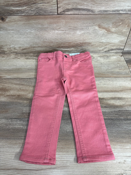 Front view of Okie Dokie toddler skinny jeans in bohemian rose showing slim legs and five pocket detail on wood background