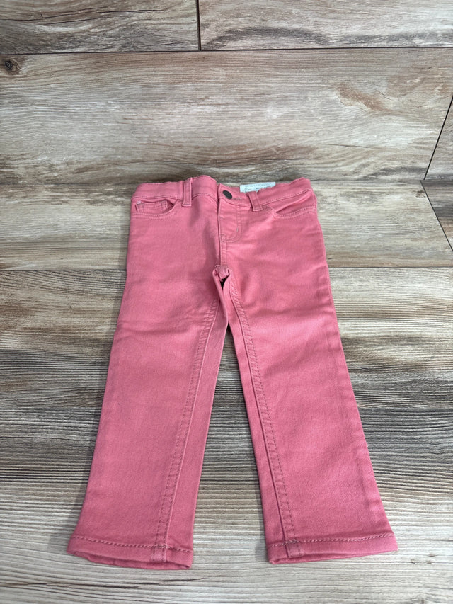 Front view of Okie Dokie toddler skinny jeans in bohemian rose showing slim legs and five pocket detail on wood background