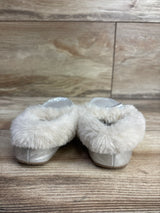 Pair of silver children's slippers with fluffy white faux fur trim on wood floor