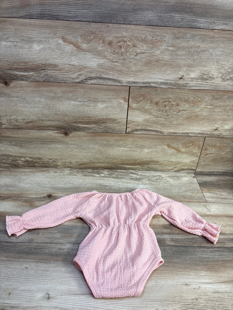 Shein textured pink long sleeve bubble romper for baby size 12-18m on a wood background