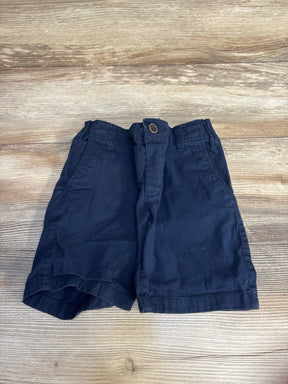 Navy blue toddler shorts with button waist, laid flat on wood floor for kids clothing resale