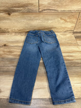 Kids' blue denim jeans with elastic waist, laid flat on wood floor