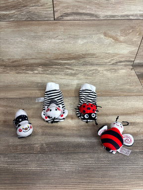 Top view of baby wrist rattle socks and foot finders set showing black-and-white stripes and red accents on wood background