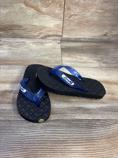 Top view of Locals Original translucent blue-strap slippah flip flops, size 7.5c, textured black sole on wood backdrop