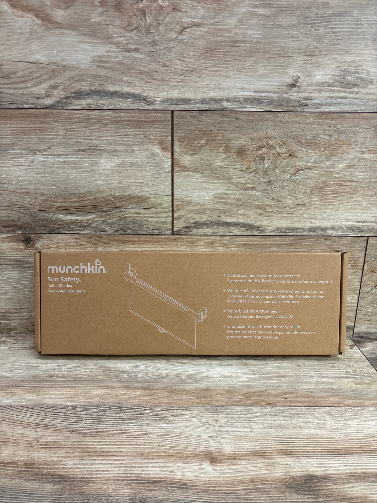 Front view of Munchkin Sun Safety Car Window Roller Shades 2pk box showing UVA and UVB blocking on wood-patterned background