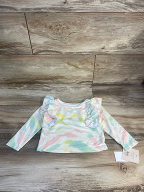 Pastel tie-dye long sleeve baby shirt with ruffle shoulders, laid on wood background