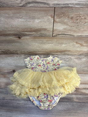 Yellow baby girl romper dress with ruffled tulle skirt and cartoon print, displayed on wood.