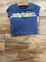 Front flat lay of Roxy toddler short-sleeve shirt size 3T showcasing pastel floral stripe and ROXY logo on wooden floor