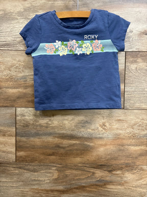 Front flat lay of Roxy toddler short-sleeve shirt size 3T showcasing pastel floral stripe and ROXY logo on wooden floor