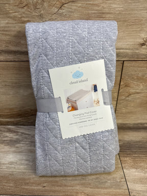 Front view of Cloud Island grey quilted changing pad cover folded, showing diagonal stitching and label on wood background