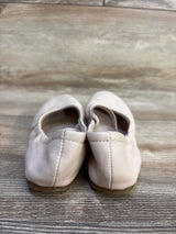 Light pink toddler ballet flats on wood floor, gently used children's shoes resale