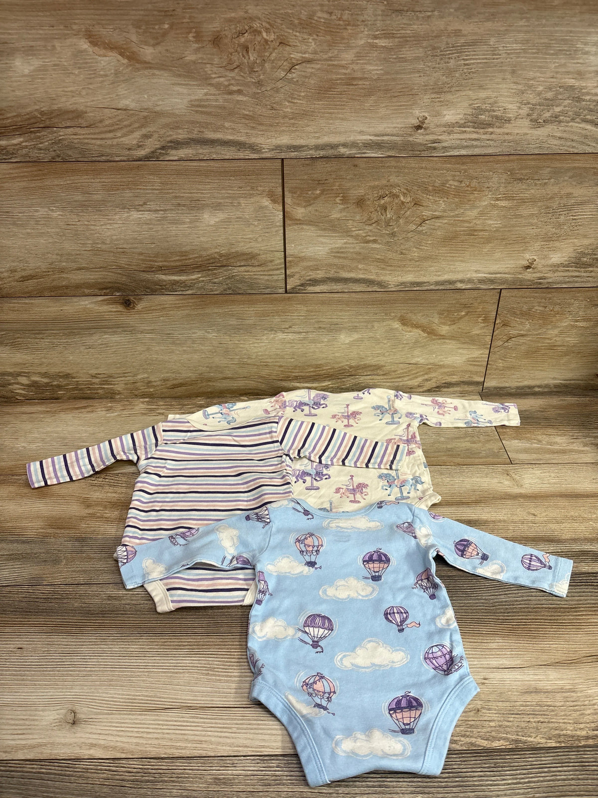 Member's Mark 3-pack organic cotton long-sleeve bodysuits for babies in blue and ivory