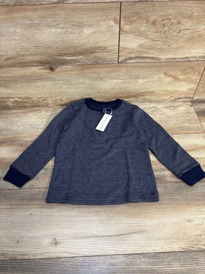 Navy blue long sleeve striped toddler shirt with crew neck, laid flat on wooden floor