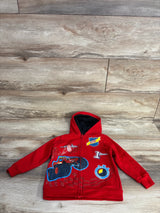 Red kids hoodie with Blaze monster truck design, characters, and racing patches on wooden floor