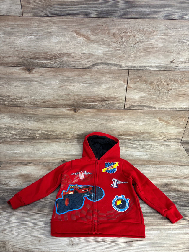Red kids hoodie with Blaze monster truck design, characters, and racing patches on wooden floor