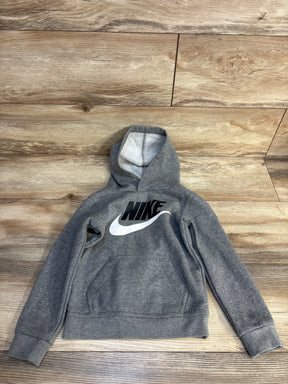 Gray Nike kids hoodie with black logo, laid flat on wood floor for resale