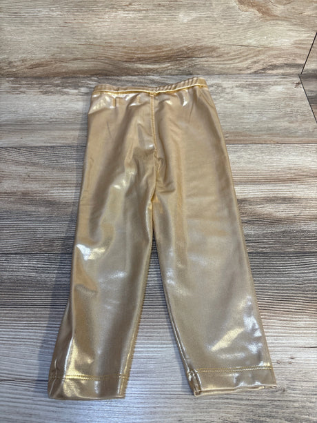 Shiny gold toddler leggings with elastic waistband on wood background