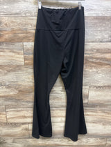 Black maternity flared leggings by Me n Mommy To Be displayed against a wood-panel background